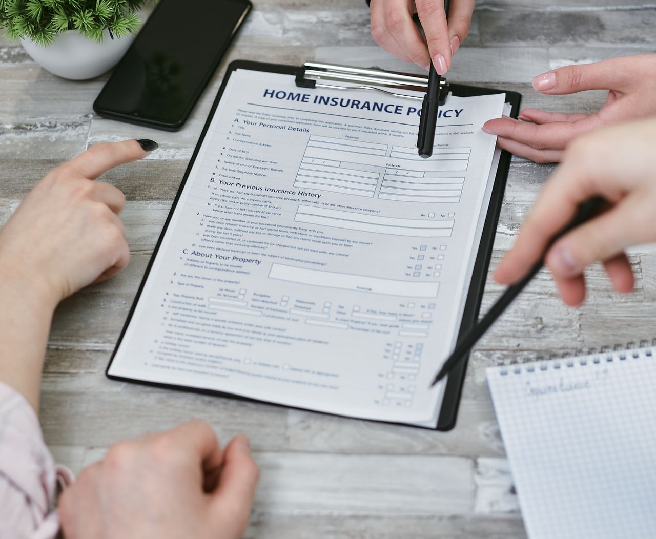 Contact Three individuals collaborating on a home insurance policy document. Elements include a clipboard, notes, and pointing hands.